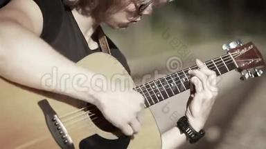 一位长发吉他手用简单的和弦弹唱一首歌的白镜头